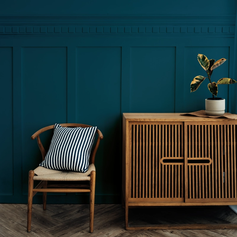 scandinavian-vintage-wood-cabinet-with-chair-by-dark-blue-wall