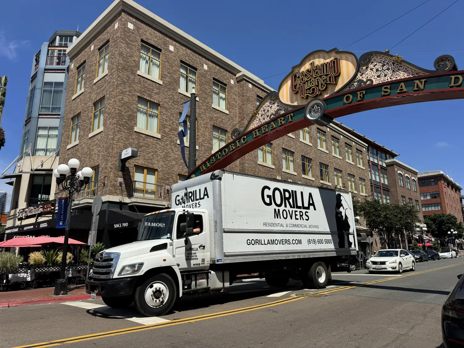 Gorilla Movers truck driving under the Gaslamp Quarter archway on Fifth Avenue in downtown San Diego
