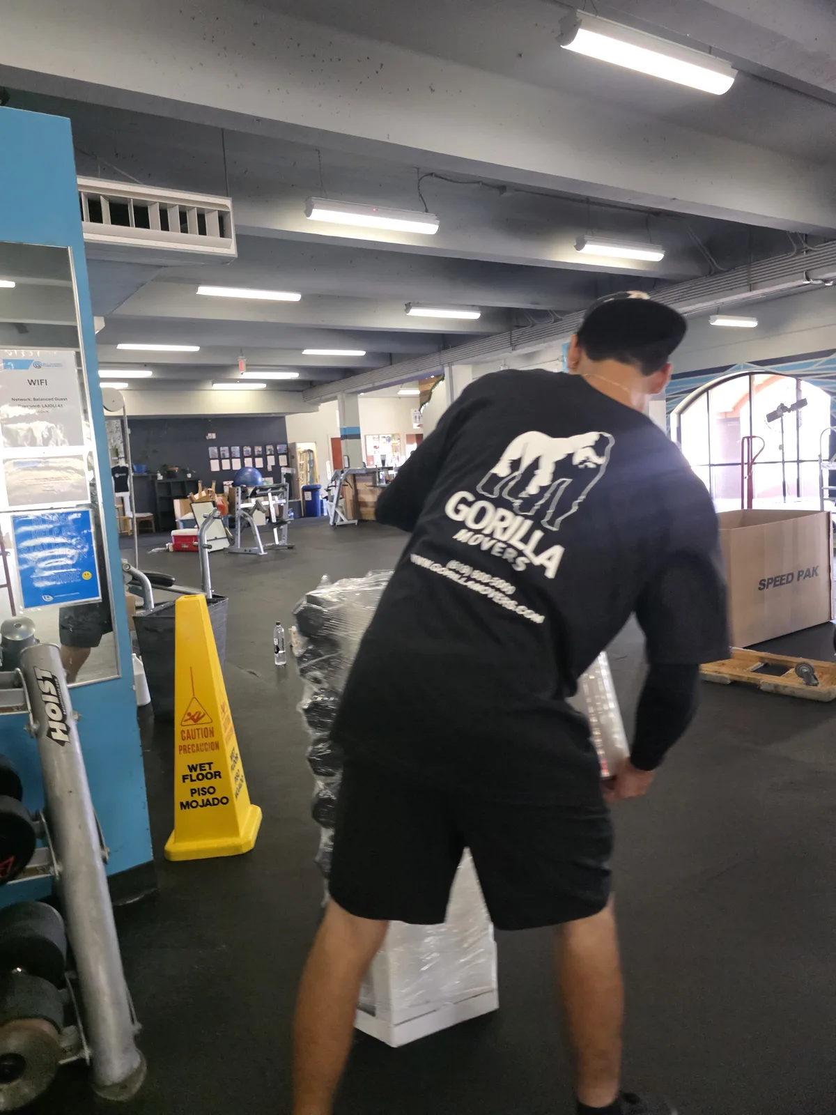 Gorilla Movers wrapping leg press machine for La Jolla gym relocation