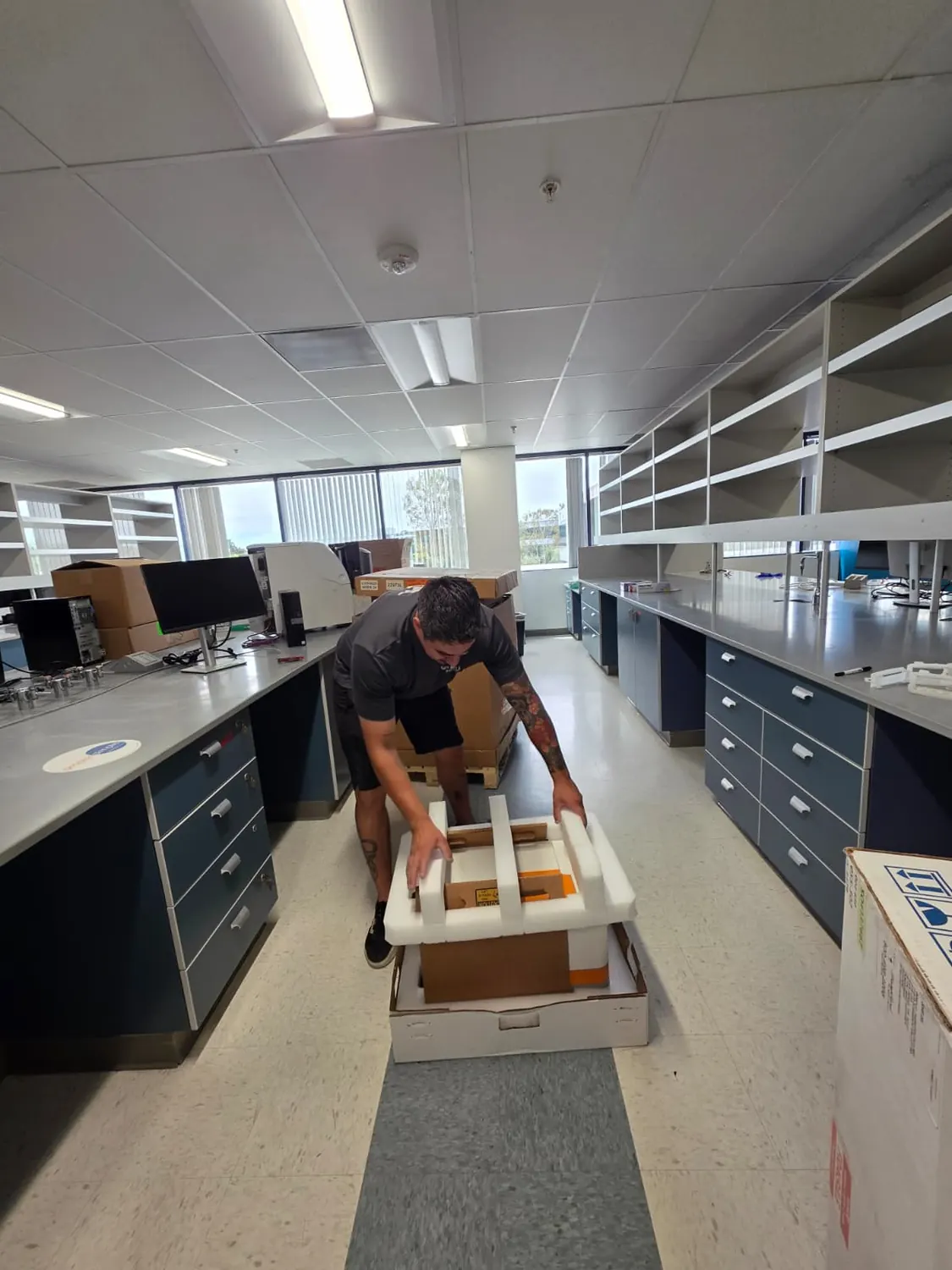 Gorilla Movers crew foam-packing a benchtop lab instrument into its crate during a phased San Diego lab move