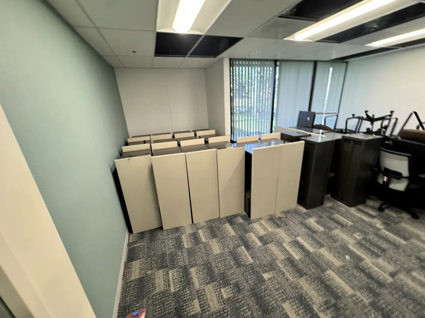 Cubicle panels staged for teardown and decommission in a San Diego office