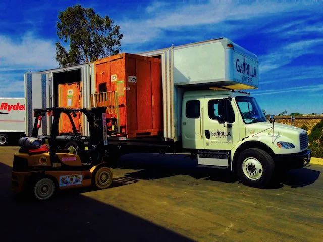 Gorilla Movers truck with a wooden storage vault being loaded by forklift in San Diego